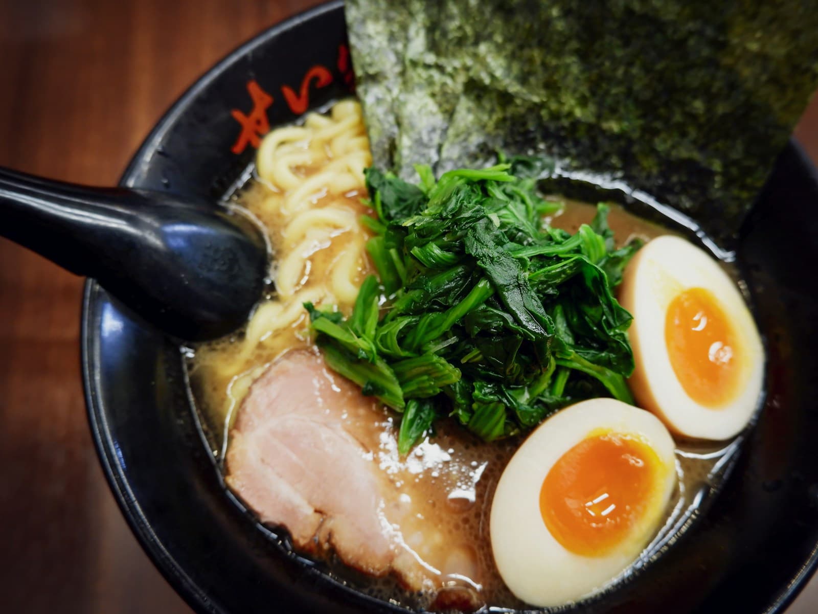 味玉と青菜がのった特製ラーメンの写真